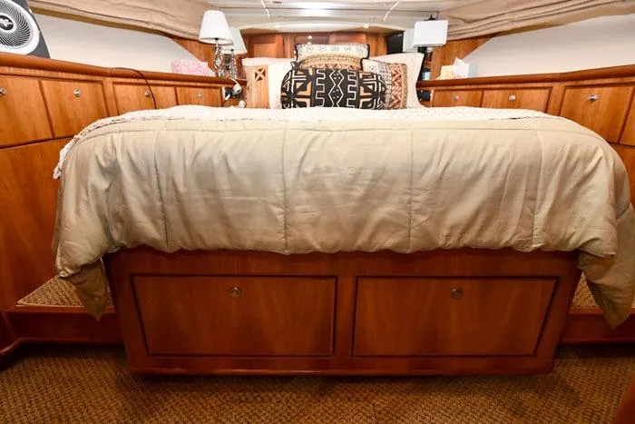  Yacht Photos Pics Luxurious bedroom interior of 2001 Symbol Raised Pilothouse Motoryacht with elegant bedding and wood cabinetry.
