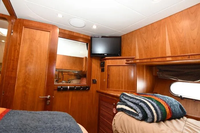  Yacht Photos Pics Luxurious 2001 Symbol Raised Pilothouse Motoryacht cabin with wood paneling and cozy bedding.