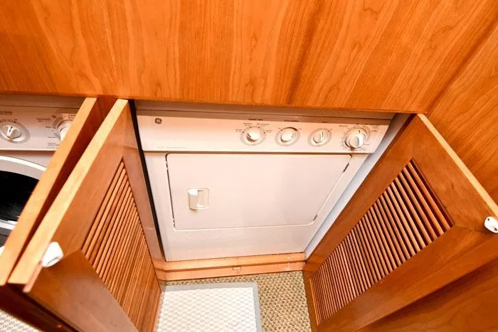  Yacht Photos Pics Laundry area with wooden cabinets on a 2001 Symbol Raised Pilothouse Motoryacht.