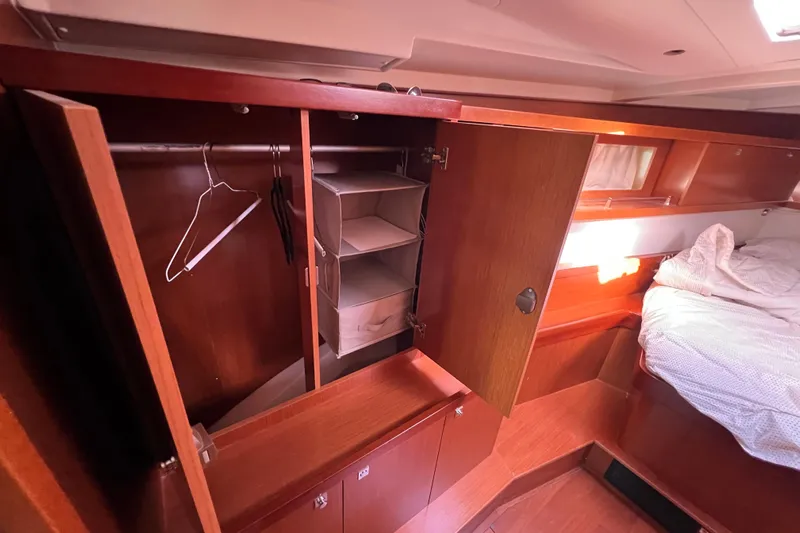 Adattare Yacht Photos Pics Interior of 2012 Beneteau Oceanis 45 showing wooden wardrobe and cozy bed.