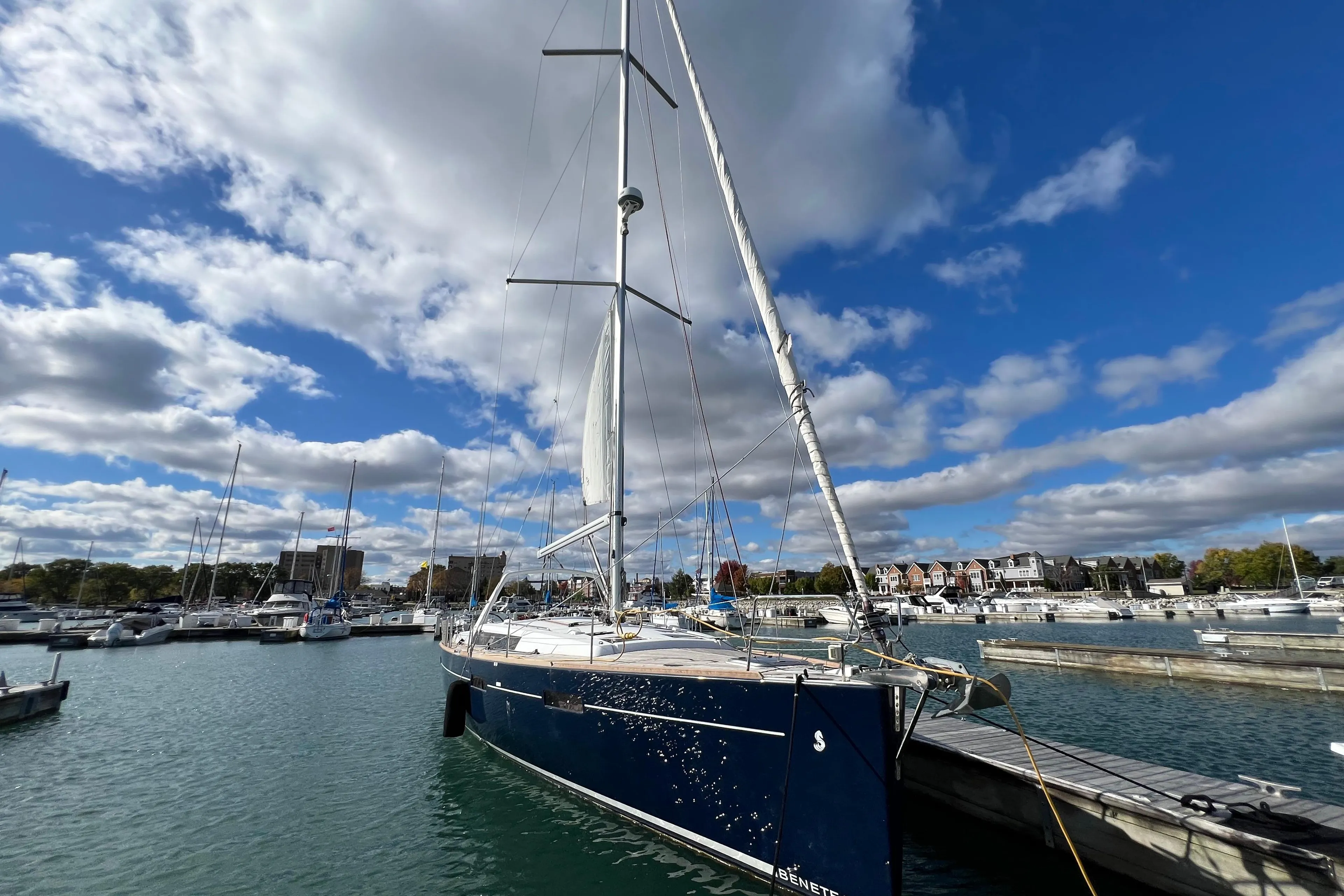 2012 Beneteau Oceanis 45 sailboat docked in a marina under a partly cloudy sky.
