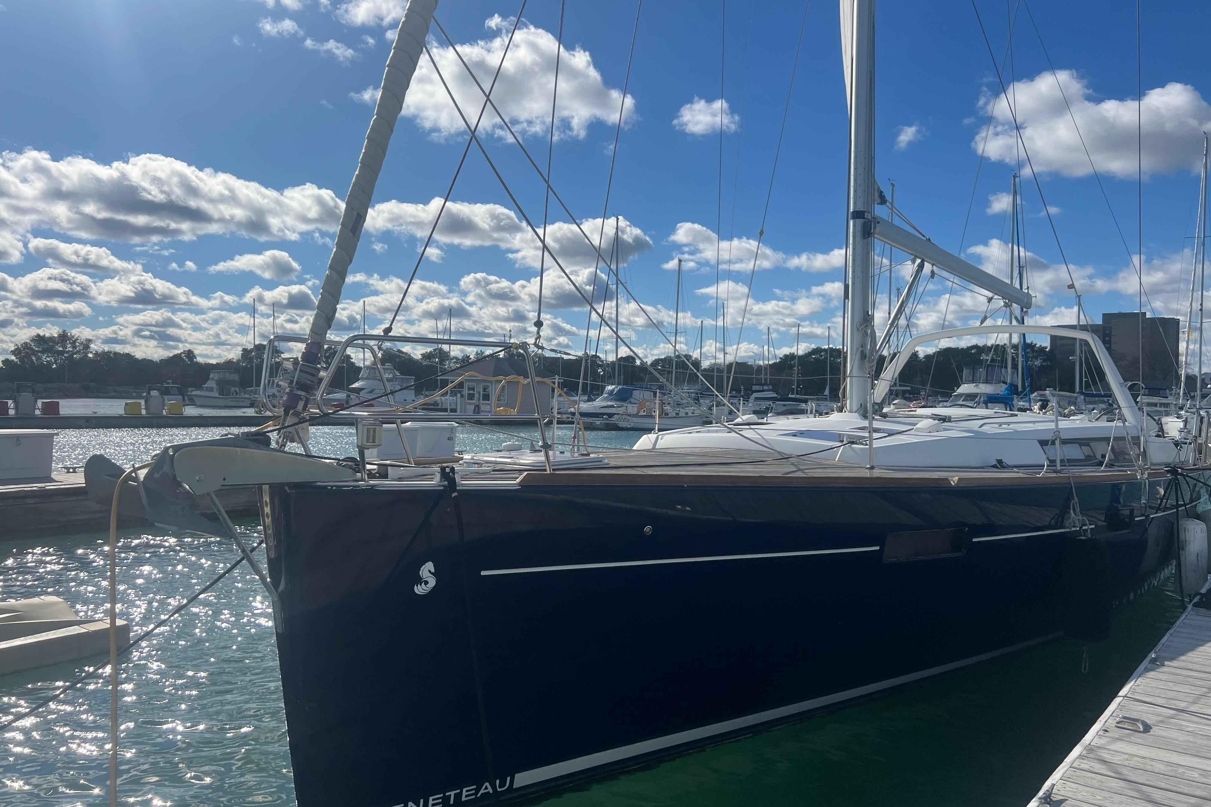 Sailboat Beneteau Oceanis 45, 2012 model, docked at marina under blue sky.