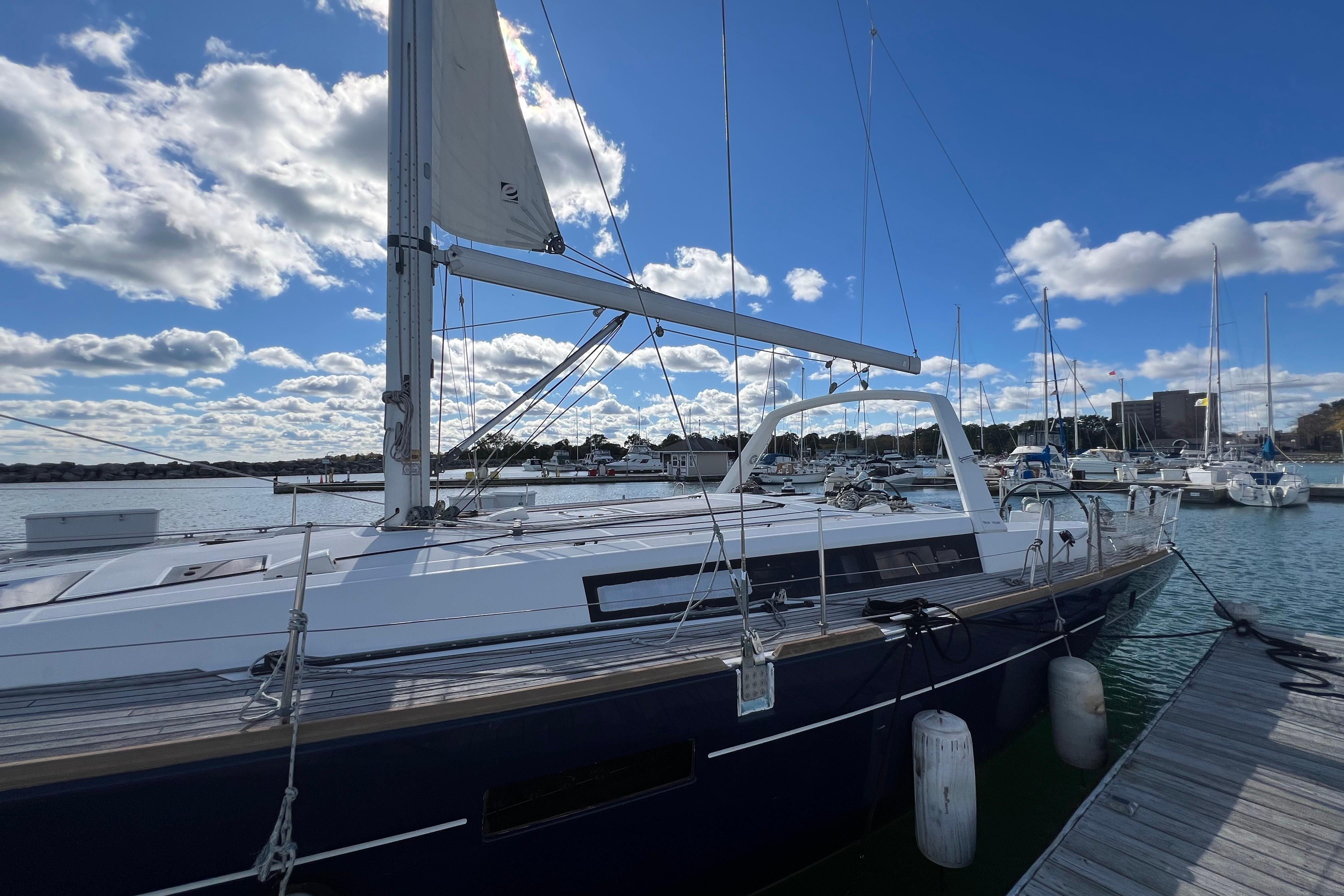 Sailboat Beneteau Oceanis 45, 2012 model, docked at marina under blue sky.
