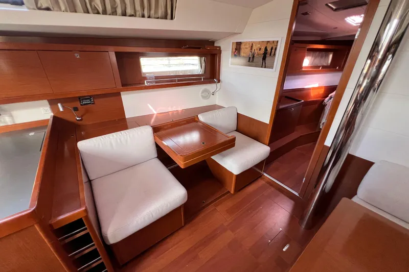 Adattare Yacht Photos Pics Interior of 2012 Beneteau Oceanis 45 yacht with wooden furnishings and cozy seating area.