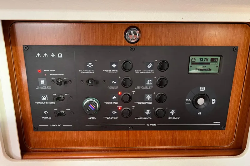 Adattare Yacht Photos Pics Control panel of a 2012 Beneteau Oceanis 45 yacht, featuring various switches and a digital display.
