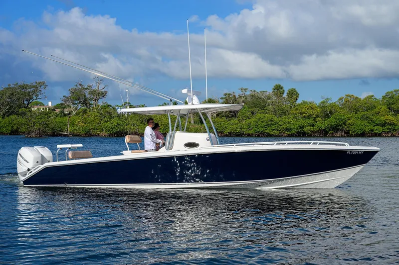  Yacht Photos Pics 2005 Venture 34 Center Console boat cruising on a calm waterway with lush greenery.
