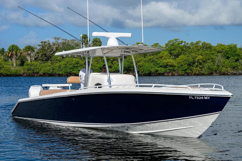  Yacht Photos Pics 2005 Venture 34 Center Console boat on calm water, lush greenery in background.