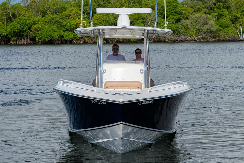  Yacht Photos Pics 2005 Venture 34 Center Console boat on calm water with lush green background.