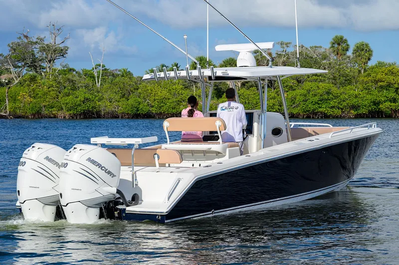  Yacht Photos Pics 2005 Venture 34 Center Console boat with dual Mercury engines on a calm waterway.