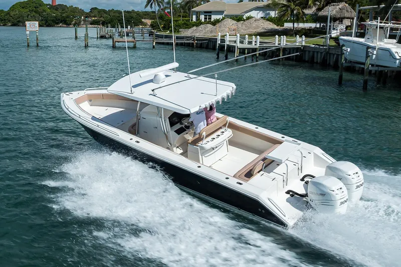  Yacht Photos Pics 2005 Venture 34 Center Console boat cruising on water with twin Mercury engines.