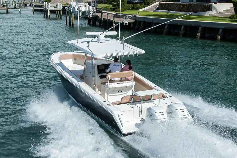  Yacht Photos Pics 2005 Venture 34 Center Console boat cruising on water near docks.