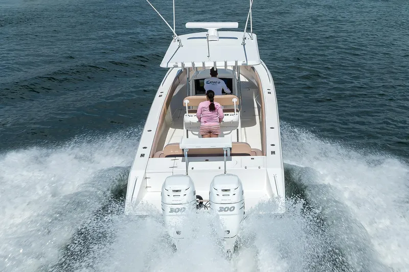  Yacht Photos Pics 2005 Venture 34 Center Console boat cruising on open water, rear view.