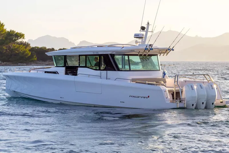  Yacht Photos Pics 2025 Axopar 45 XC Cross Cabin boat cruising on serene waters.