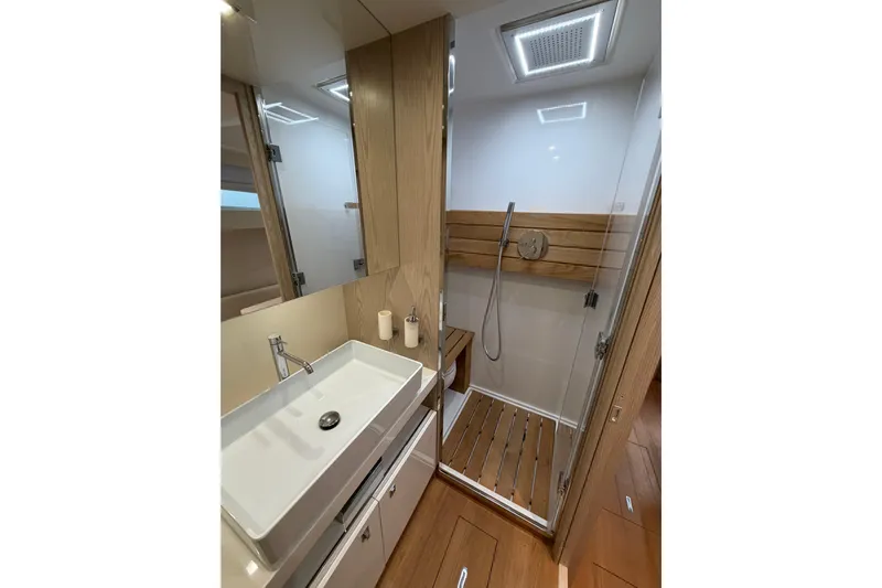 Kawa Yacht Photos Pics Luxurious bathroom in 2023 SACS Rebel 55 yacht with modern fixtures and wooden accents.