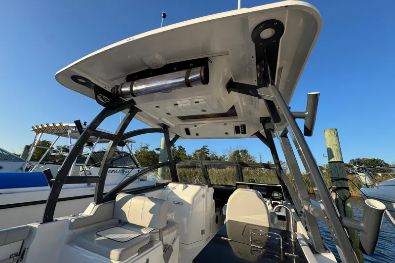  Yacht Photos Pics 2023 Sea Fox 268 Traveler boat interior with seating and canopy, docked by the water.