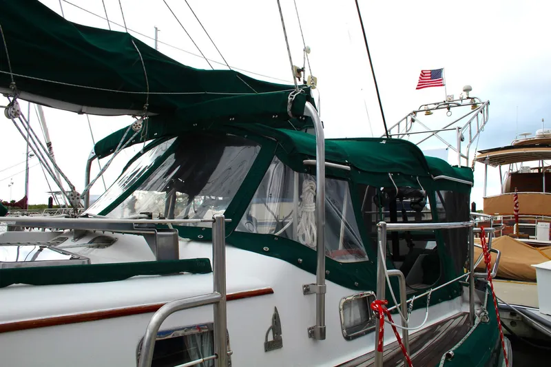 Divine Miss Em Yacht Photos Pics Sailboat with green canopy, Slocum 43, 1990 model, docked with American flag.