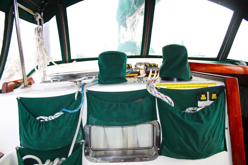 Divine Miss Em Yacht Photos Pics Interior of a 1990 Slocum 43 sailboat cockpit with green covers and ropes.