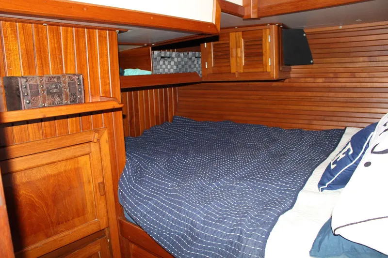 Divine Miss Em Yacht Photos Pics Cozy wooden cabin interior of 1990 Slocum 43 sailboat with bed and storage.
