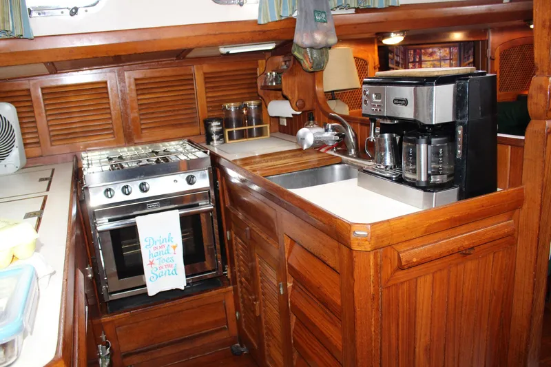 Divine Miss Em Yacht Photos Pics Cozy 1990 Slocum 43 yacht kitchen with stove, sink, and coffee maker.
