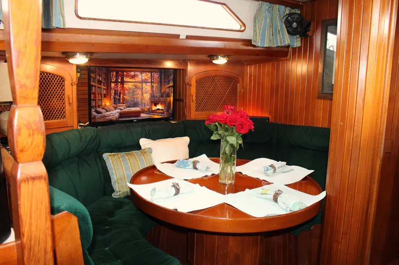 Divine Miss Em Yacht Photos Pics Cozy 1990 Slocum 43 yacht interior with dining area, wooden paneling, and floral centerpiece.