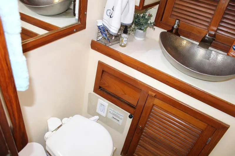Divine Miss Em Yacht Photos Pics 1990 Slocum 43 yacht bathroom with wooden cabinets and modern sink.