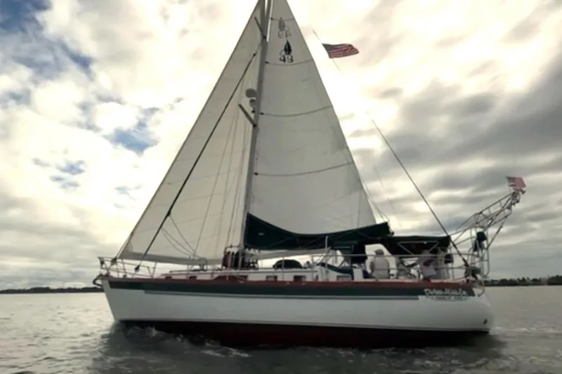 Divine Miss Em Yacht Photos Pics Sailing yacht Slocum 43 from 1990 on open water under cloudy skies.