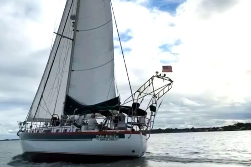 Divine Miss Em Yacht Photos Pics Sailing yacht Slocum 43 from 1990 on open water under cloudy skies.