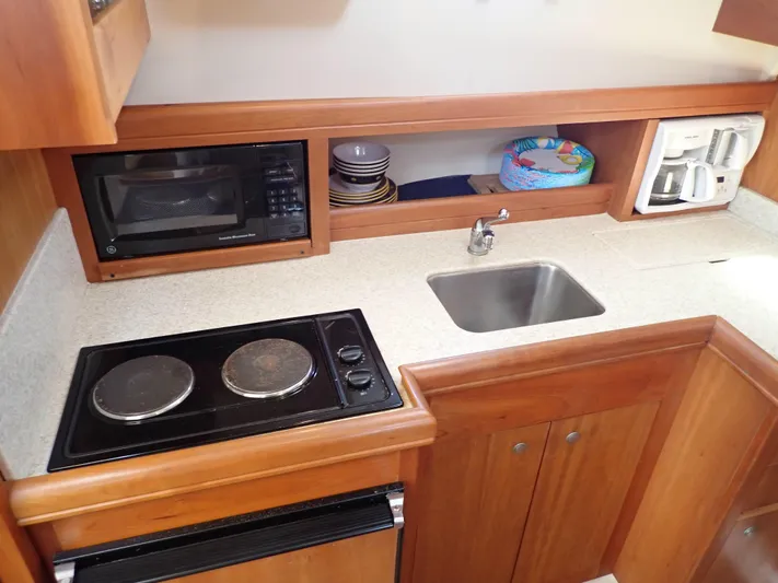  Yacht Photos Pics 2004 Mainship 34 Rum Runner II galley with stove, sink, microwave, and coffee maker.