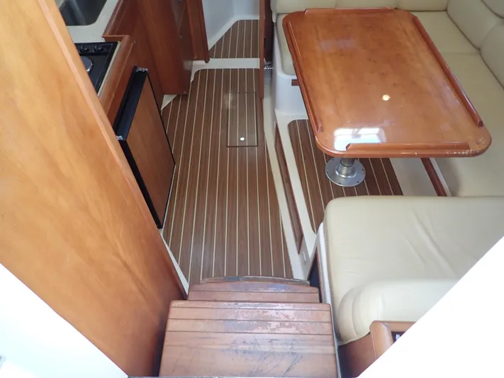  Yacht Photos Pics 2004 Mainship 34 Rum Runner II interior with wood flooring and dining area.