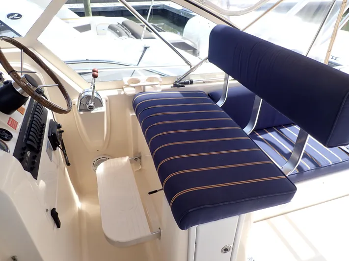  Yacht Photos Pics 2004 Mainship 34 Rum Runner II helm with blue striped seating and steering wheel.