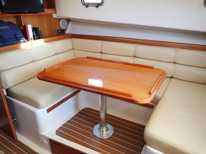  Yacht Photos Pics 2004 Mainship 34 Rum Runner II interior with beige seating and wooden table.