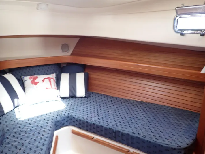  Yacht Photos Pics 2004 Mainship 34 Rum Runner II cabin with cozy bedding and wooden interior.
