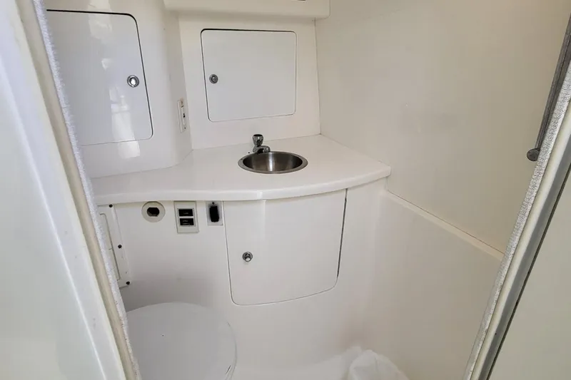  Yacht Photos Pics 2007 Intrepid 370 Cuddy boat bathroom with sink and storage cabinets.