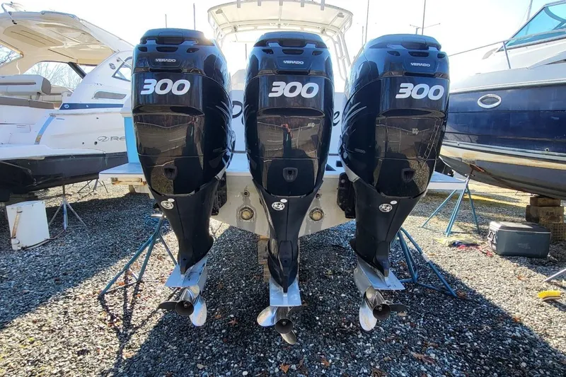  Yacht Photos Pics 2007 Intrepid 370 Cuddy with triple 300 horsepower Verado engines, docked on gravel.