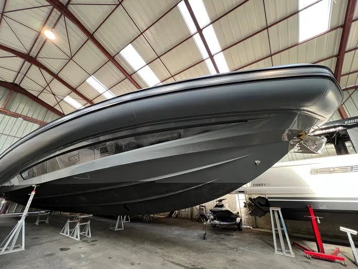 Stanislas Michel Yacht Photos Pics 2016 SACS Strider 18 boat in storage, viewed from below in a warehouse setting.