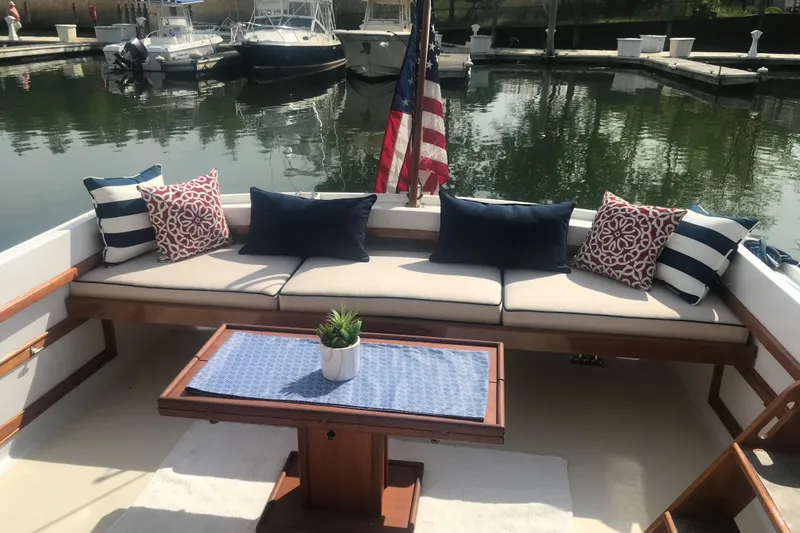 Oasis Yacht Photos Pics Elegant seating area on 1987 Wilbur 38 boat with decorative cushions and table.