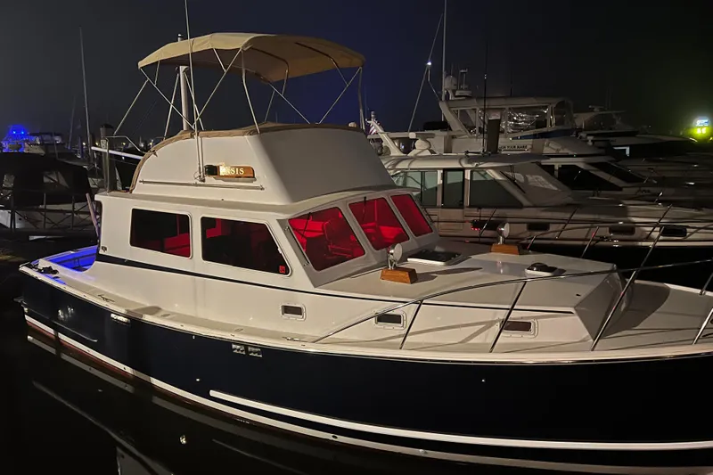 Oasis Yacht Photos Pics 1987 Wilbur 38 boat docked at night with illuminated cabin.