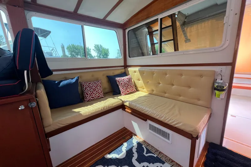 Oasis Yacht Photos Pics Cozy interior of 1987 Wilbur 38 boat with cushioned seating and decorative pillows.