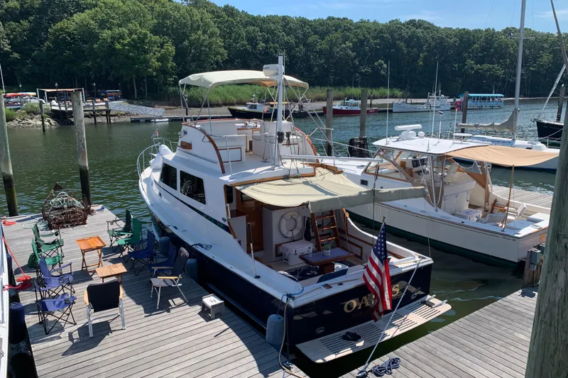 Oasis Yacht Photos Pics 1987 Wilbur 38 yacht docked at marina with chairs and American flag.