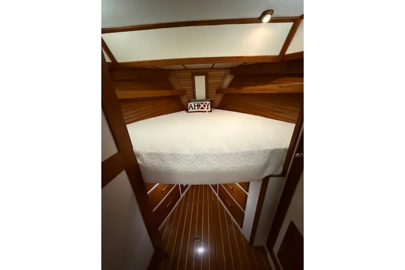 Oasis Yacht Photos Pics Cozy cabin interior of 1987 Wilbur 38 boat with wooden accents and "Ahoy" sign.