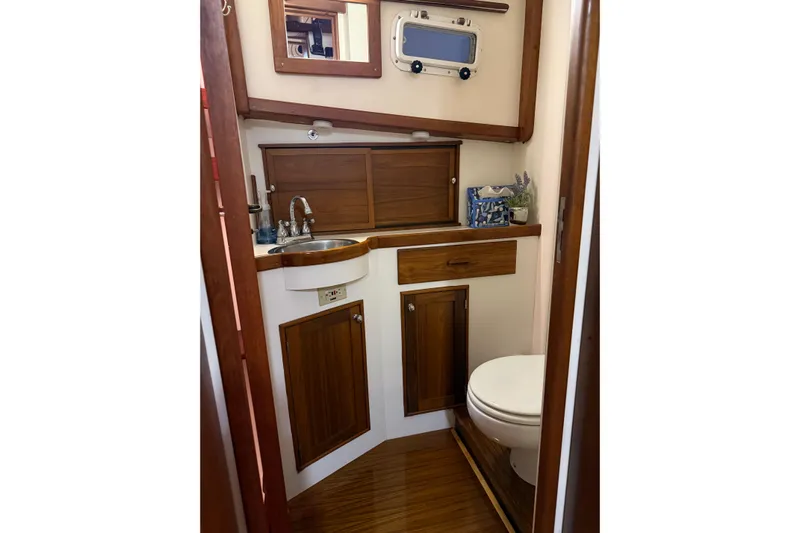Oasis Yacht Photos Pics 1987 Wilbur 38 yacht bathroom with wooden cabinetry and compact design.