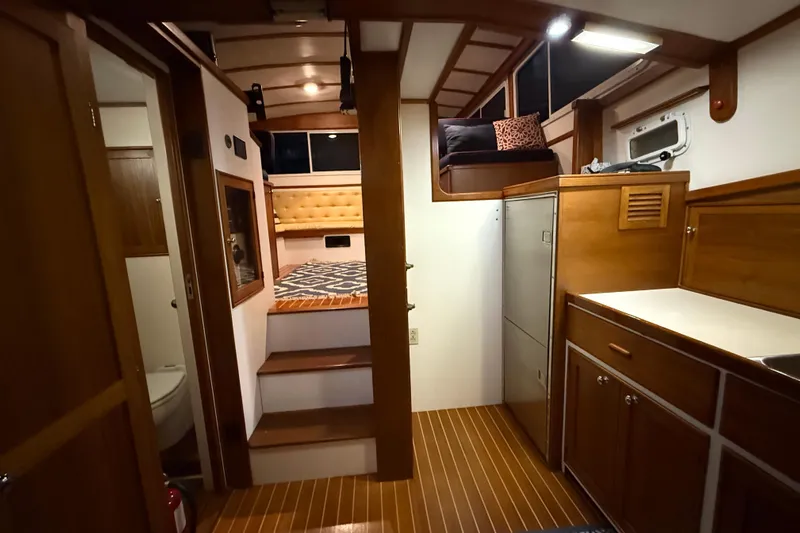 Oasis Yacht Photos Pics Interior of 1987 Wilbur 38 boat with wooden cabinetry and cozy seating area.