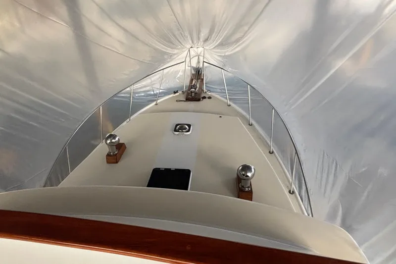 Oasis Yacht Photos Pics 1987 Wilbur 38 boat under protective cover, showcasing deck and railings.