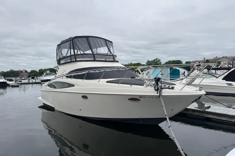 25 Knots Yacht Photos Pics 2001 Regal Commodore 3780 yacht docked at marina under cloudy sky.