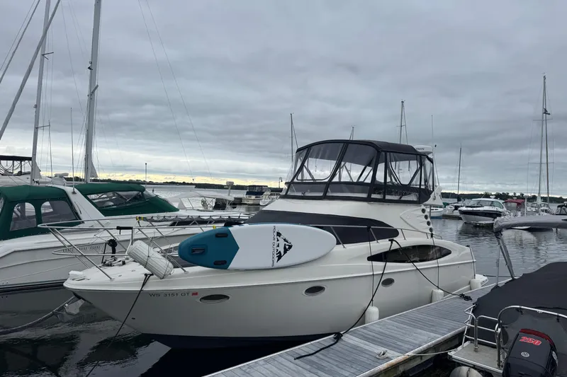 25 Knots Yacht Photos Pics 2001 Regal Commodore 3780 yacht docked at marina under cloudy sky.