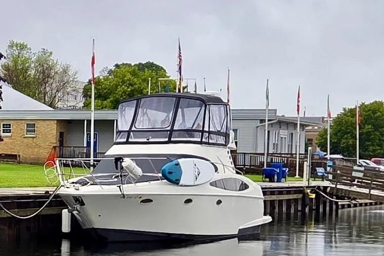 25 Knots Yacht Photos Pics 2001 Regal Commodore 3780 yacht docked at a marina with paddleboard on deck.