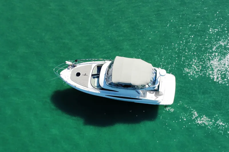 25 Knots Yacht Photos Pics Aerial view of 2001 Regal Commodore 3780 yacht on clear turquoise water.