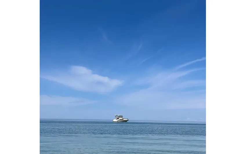 25 Knots Yacht Photos Pics 2001 Regal Commodore 3780 yacht on calm sea under clear blue sky.