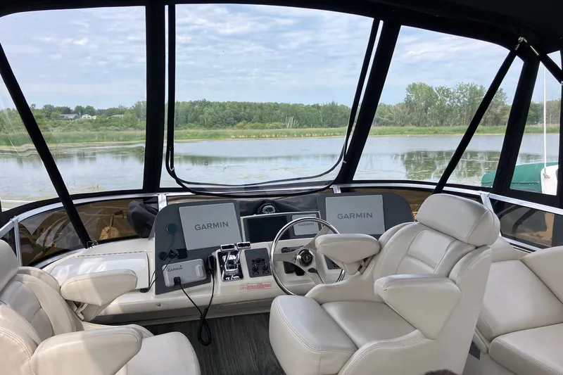 25 Knots Yacht Photos Pics 2001 Regal Commodore 3780 boat interior with Garmin navigation, overlooking serene water and greenery.