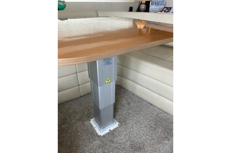 25 Knots Yacht Photos Pics Interior of 2001 Regal Commodore 3780 yacht with wooden table and cushioned seating.